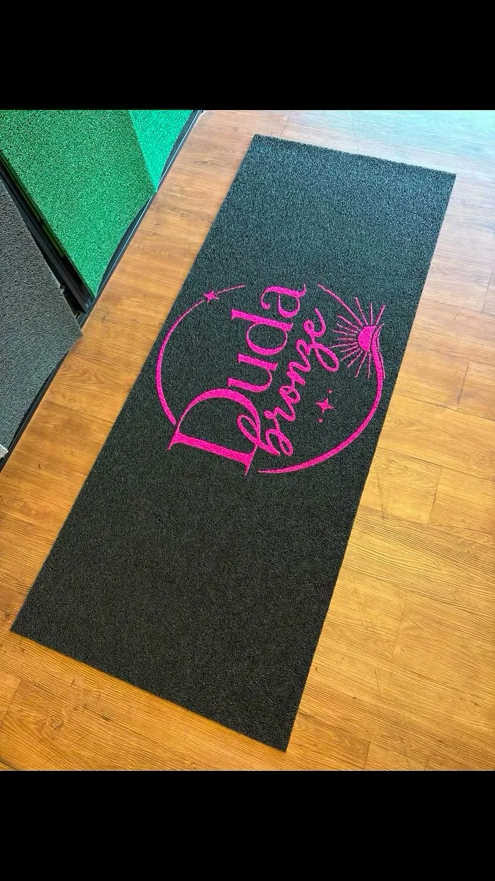 Tapete preto com a marca Duda Bronze em rosa